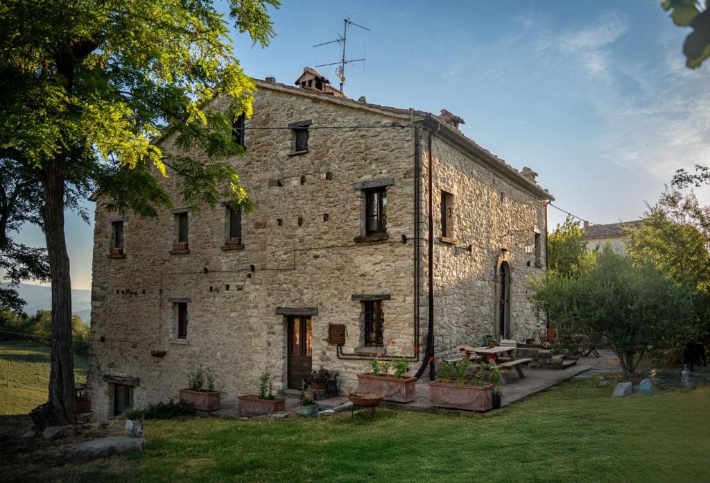 an old stone building with a table in a yard at Bed and Breakfast Ballallaluna in Maiolo