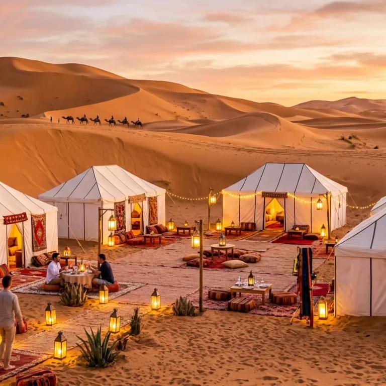 a desert wedding marquee in the desert at sunset at Merzouga Luxury Glamping in Merzouga