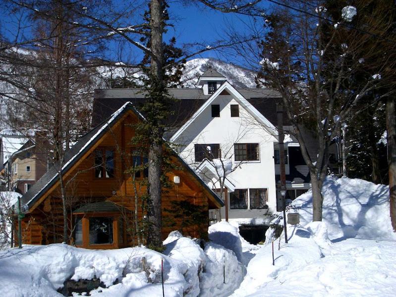 a house is covered in snow in front thereof at Kamishiro Mountain Lodge in Hakuba