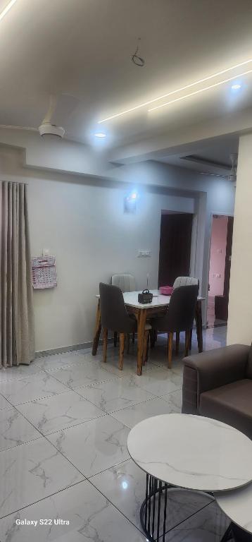 a living room with a table and chairs at Devbhumi Residency in Vadodara