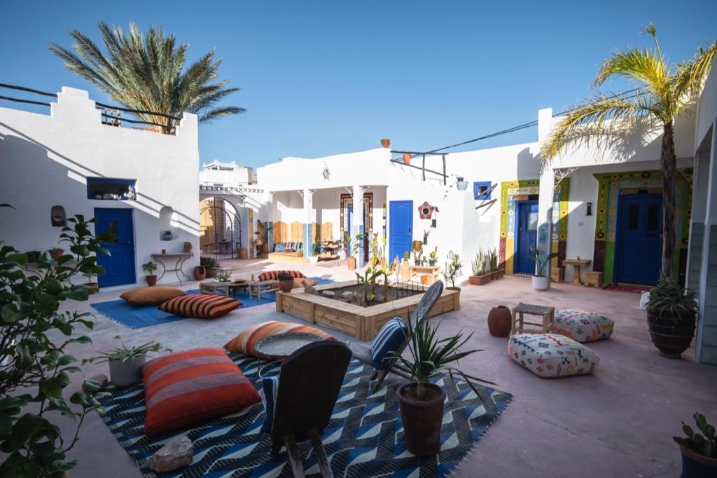 a courtyard with pillows and plants and buildings at Riad Dar Sarah in Taghazout