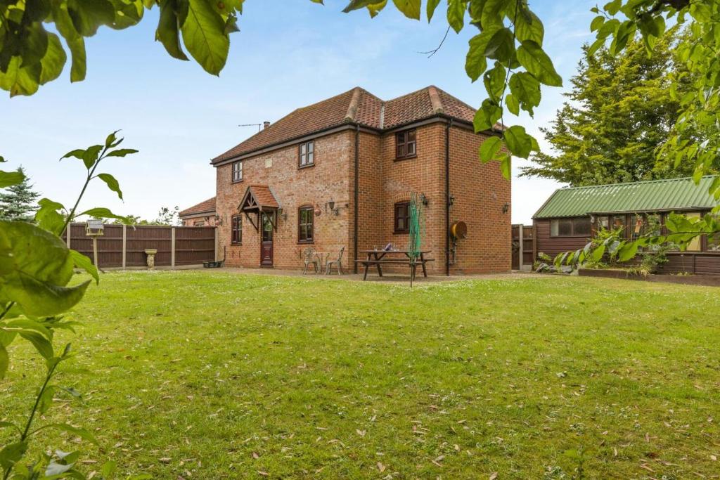 an old brick house with a green yard at 3 Bed in Acle oc-b41410 in Acle