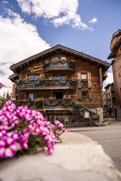 a wooden building with pink flowers in front of it at Les Monts Charvin in Courchevel