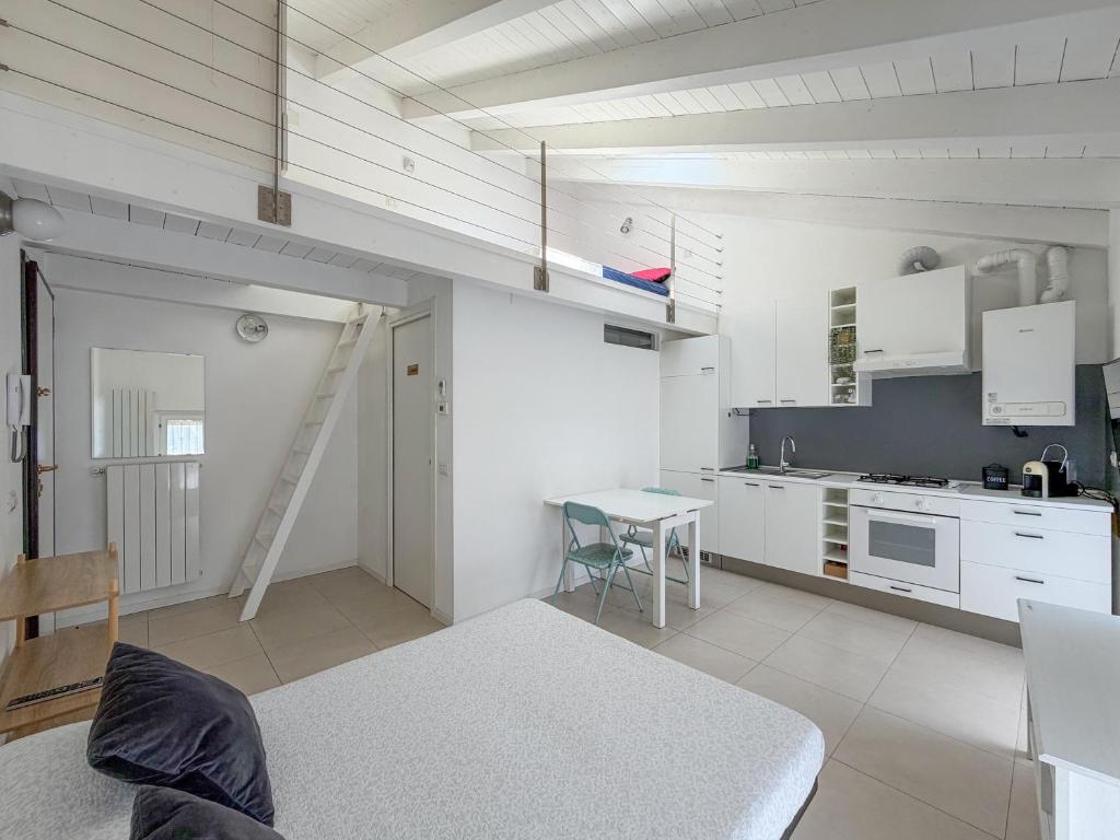 a white kitchen with a bed and a table at Roma 17 in Cassina deʼ Pecchi