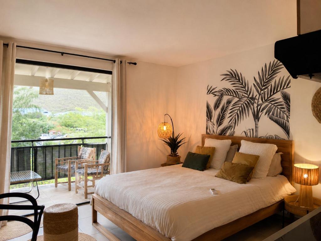 a bedroom with a large bed and a balcony at Kalista - Studio Luxueux - Anse Marcel in Saint Martin