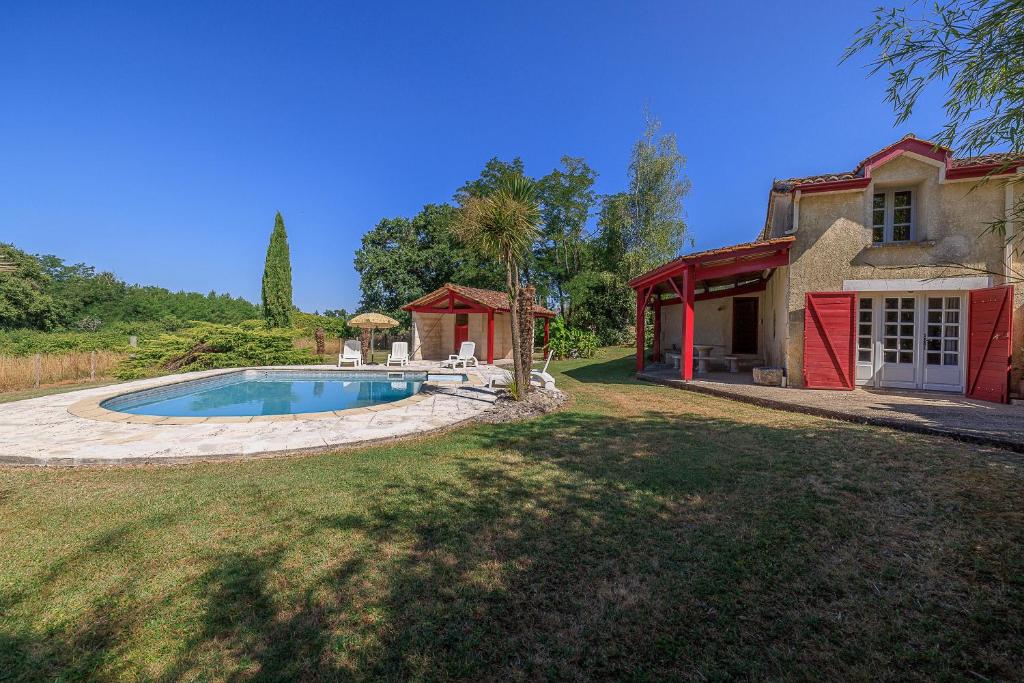 a large yard with a swimming pool in front of a house at L'Etable de Sauvignac - Avec piscine privée in Sauvignac