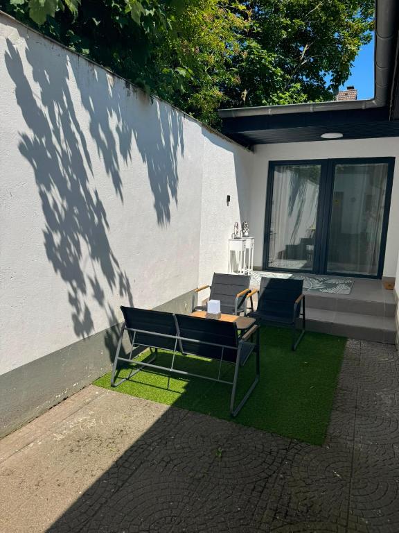 a bench and a table in front of a wall at Gemütliche City Wohnung in Mönchengladbach