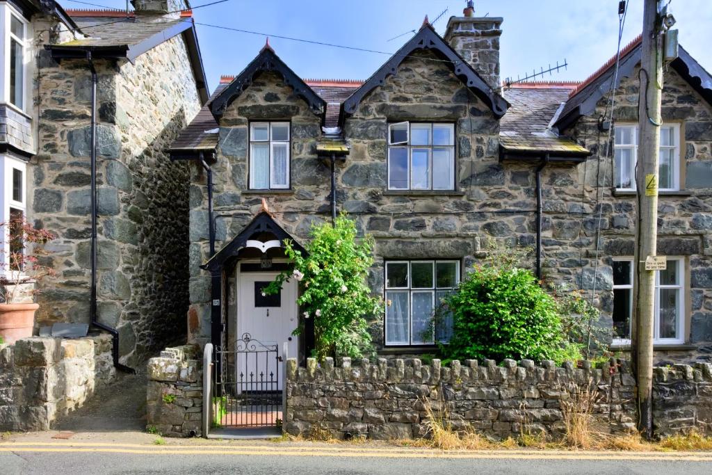 an old stone house with a white door at Finest Retreats - Artro View in Llanbedr