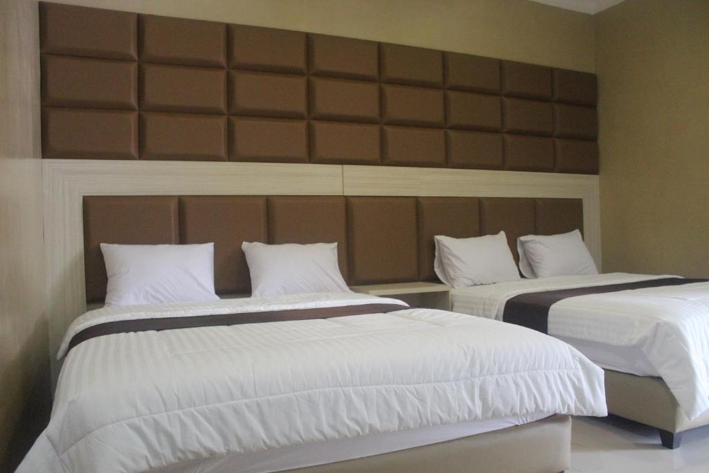 Postel nebo postele na pokoji v ubytování Cyka Raya Hotel