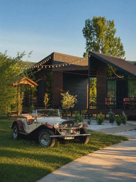 an old car parked in front of a house at Our village in Khoni