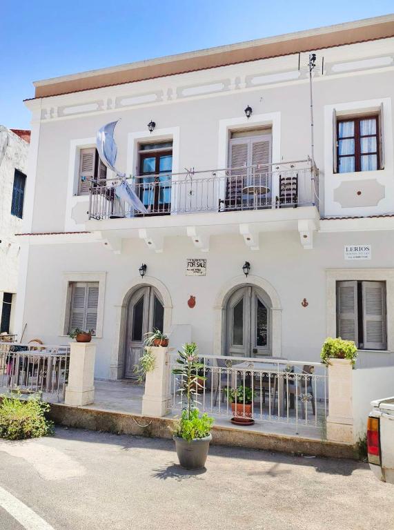 a white building with a balcony on top of it at Lerios in Vrachonisída Savoúra