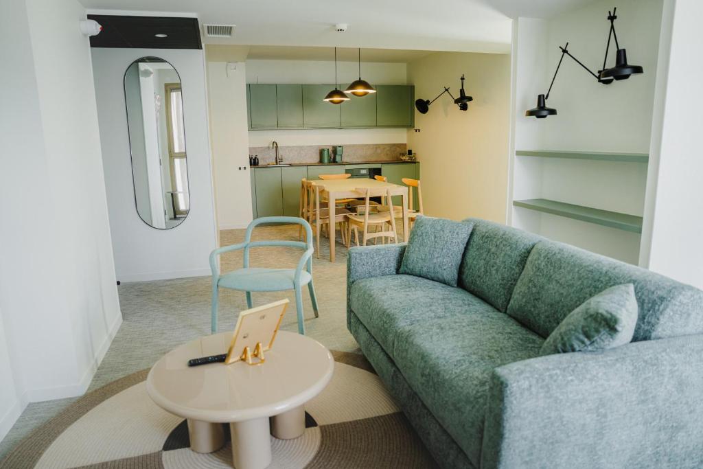 a living room with a blue couch and a table at Apparté Plus in Brive-la-Gaillarde