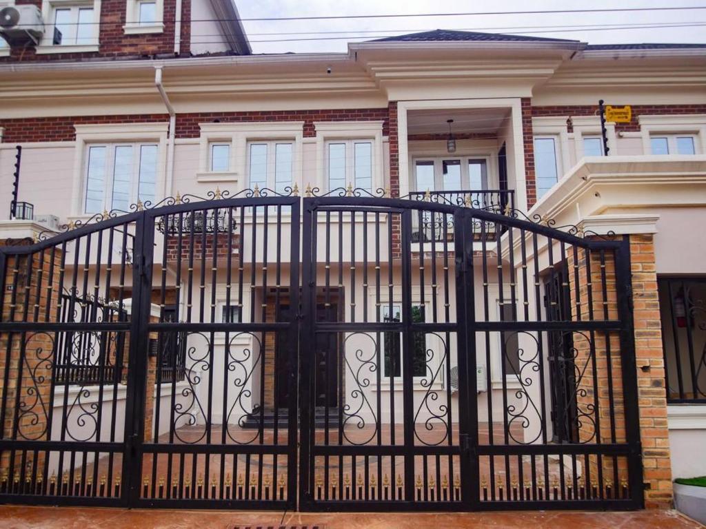 a black gate in front of a house at Two Tees Apartment in Magboro-Akeran