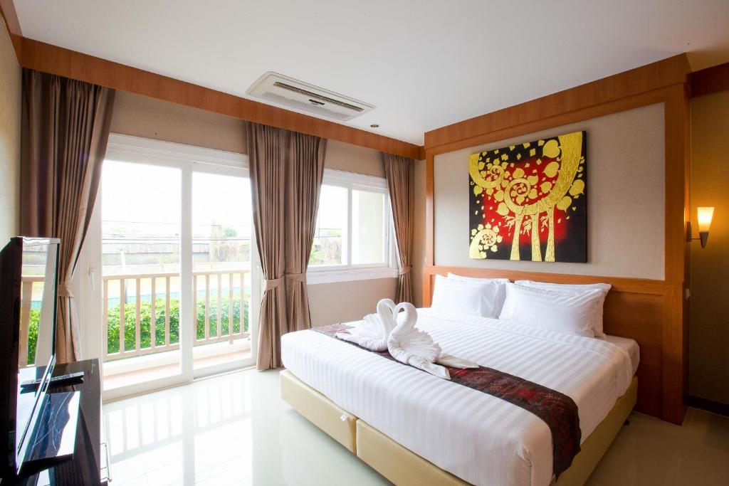 Postel nebo postele na pokoji v ubytování Romantic Khon Kaen Hotel