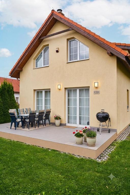 a house with a patio with a table and chairs at Villy Vlašky in Bešeňová