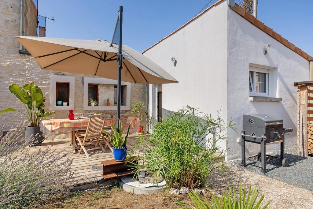 a patio with a table and an umbrella at Charmant appartement pour 4 in Saint-Jean-de-Liversay
