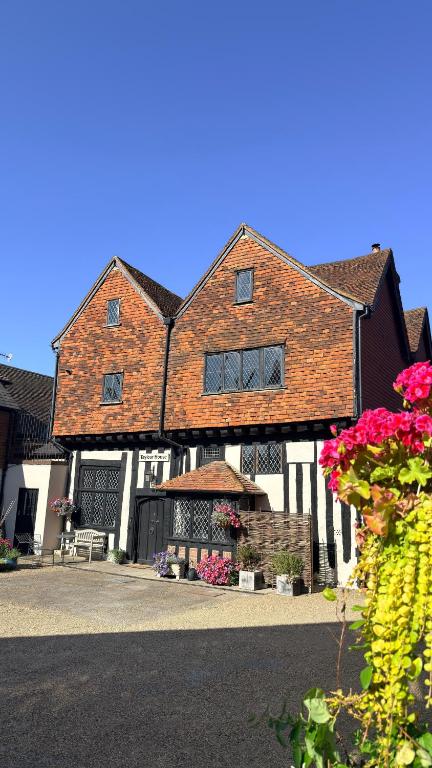 a large brick building with windows and flowers at Taylour House - Edenbridge, sleeps 10, historic, unique yet modern in Kent