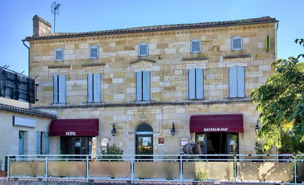 a large stone building with blue doors and windows at Hotêl - Restaurant Le Bon Duc in Les Billaux