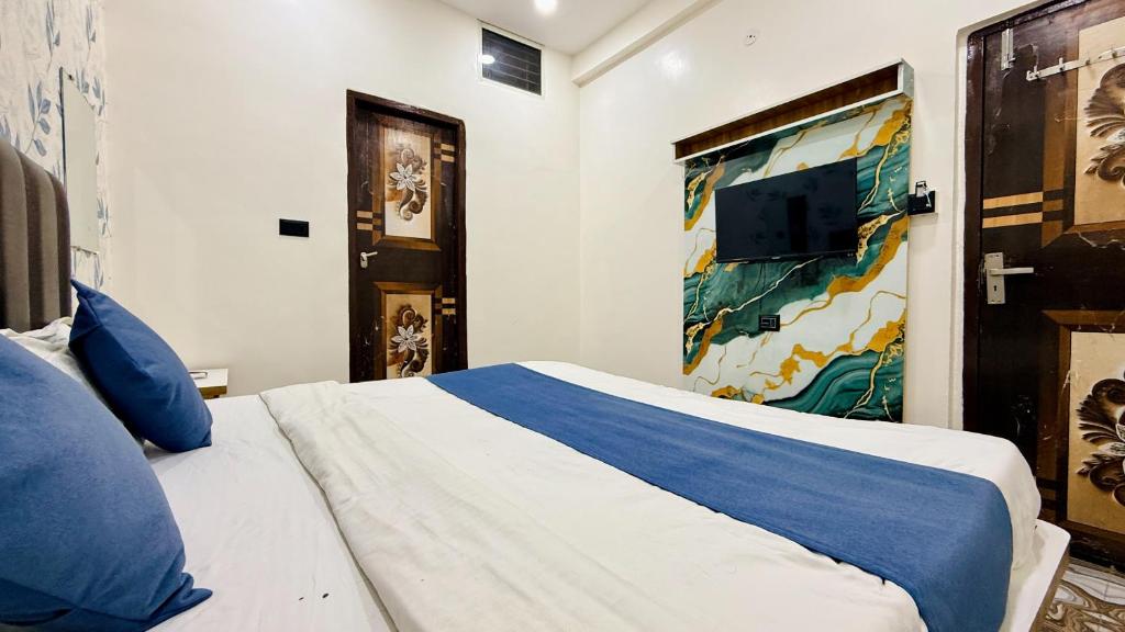 a bedroom with a large bed with blue pillows at Hotel Aashirwad in Indore