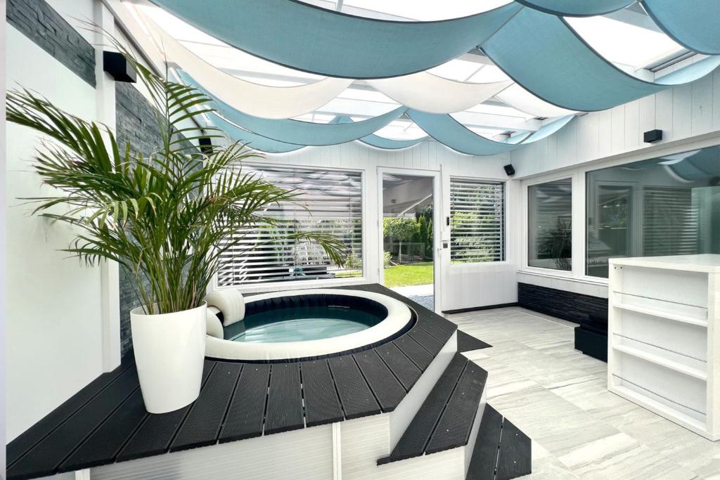 a bathroom with a hot tub with a potted plant at Lakeside Diamond Apartment - Krumpendorf in Krumpendorf am Wörthersee