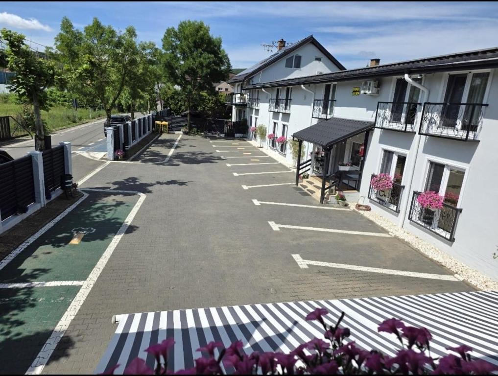 an empty parking lot next to a white building at Pensiunea Vila Chesa in Corunca