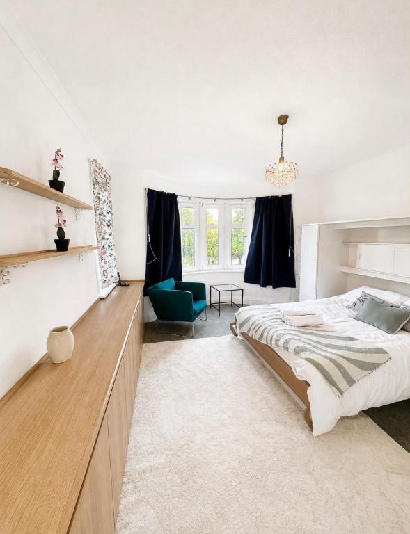 a bedroom with a bed and a blue chair at Riverside all for you in Kingston upon Thames