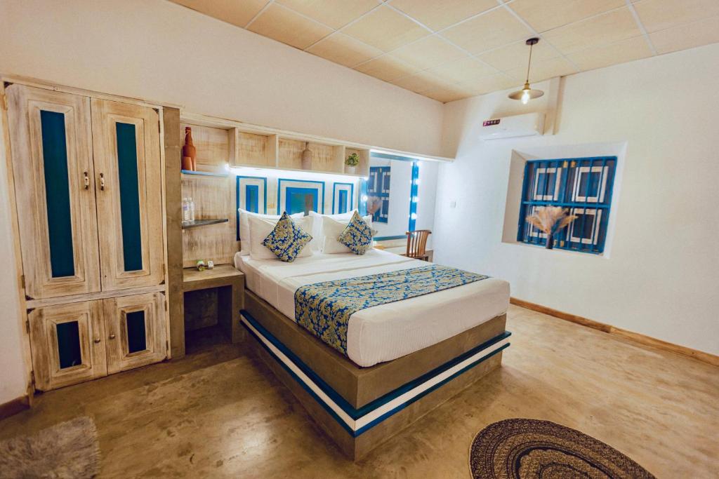 a bedroom with a bed and a desk in it at Ivy Cottage Ahangama in Ahangama