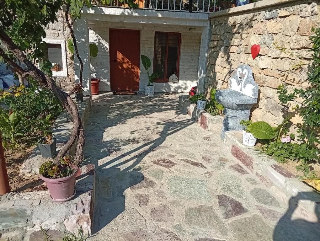 a courtyard with a stone house with a statue at Guest House Castle in Koman