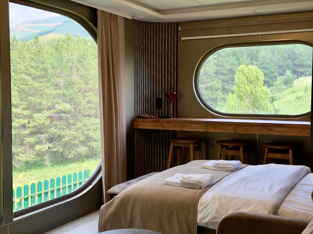 a bedroom with two beds and a large window at Econest Aparan in Aparan
