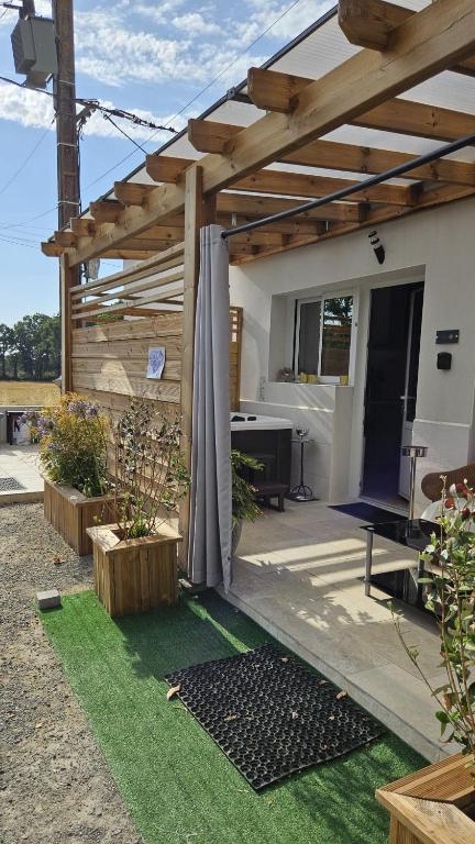 a patio with a wooden pergola and grass at Résidence L'Hermitière, CADRE VERDOYANT-FONCTIONNEL-GRAND CONFORT-PARKING WIFI GRATUIT in Saint-Même-le-Tenu