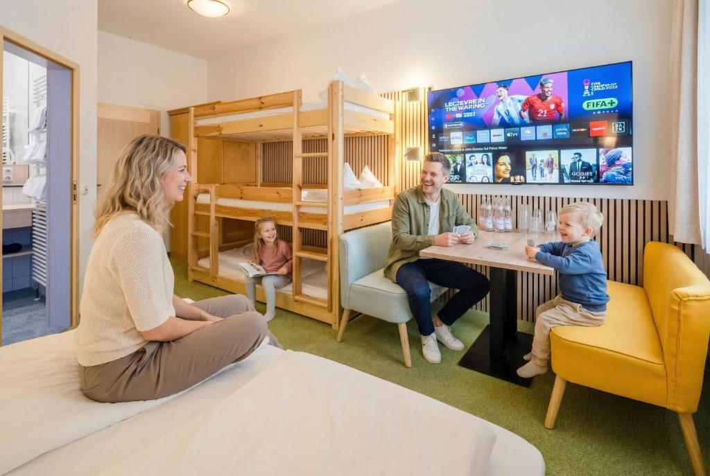 a family sitting at a table in a room at Hotel Nummerhof in Erding