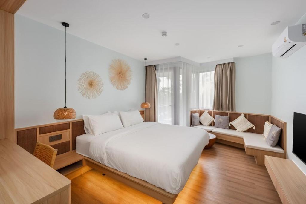 a bedroom with a large white bed and a couch at Modern Studio at Wing Samui in Bophut
