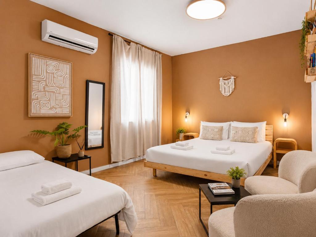 a hotel room with two beds and a couch at Localz House- Trumpeldor Beach in Tel Aviv