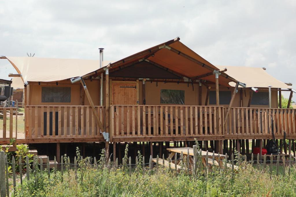 a wooden house with a porch and a deck at Lodge in de Ijsmolenhoeve in Ronse