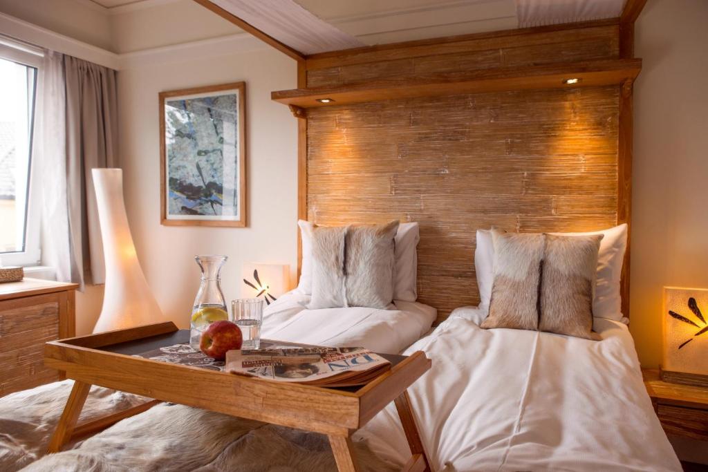 a bedroom with two beds and a wooden headboard at Oslo Guldsmeden in Oslo