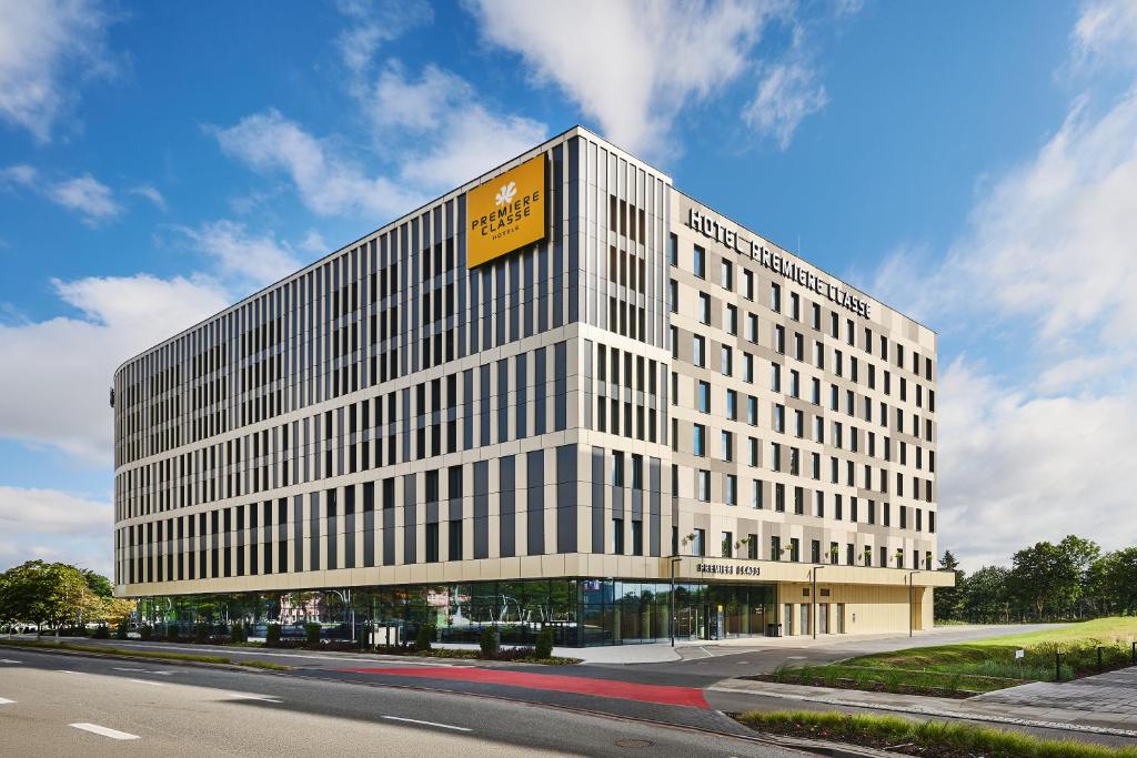 a tall white building with a yellow sign on it at Première Classe Warsaw Airport in Warsaw
