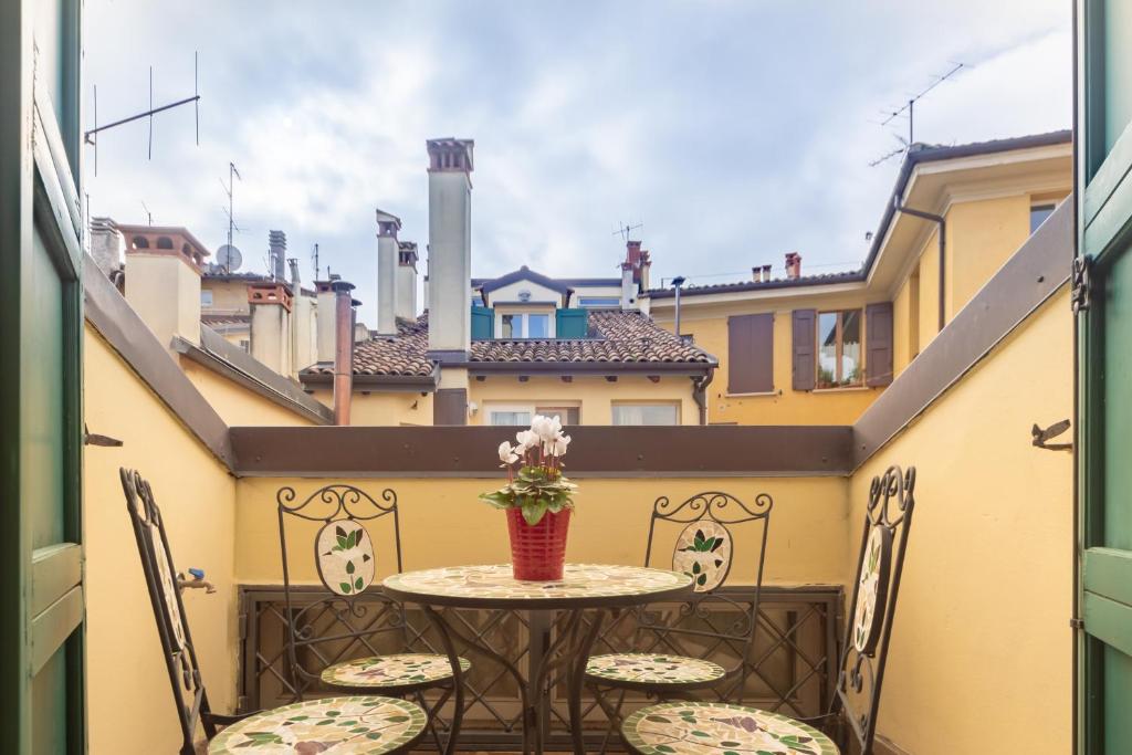 a small table and chairs on a balcony with a view at BolognaRoomscom - Santo Stefano Apartments in Bologna