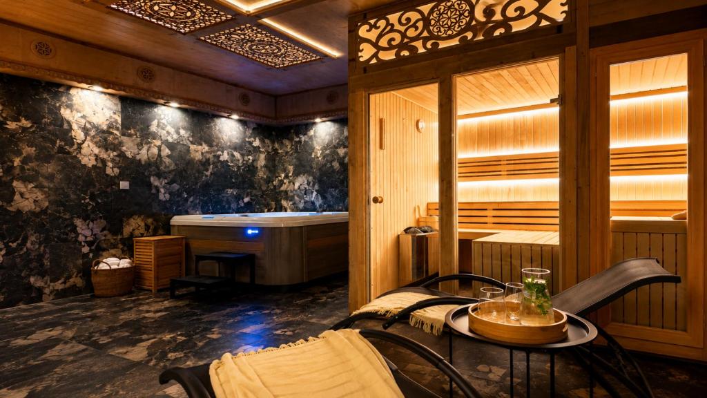 a room with a tub and a table with a table at Willa Janowa & SPA in Bukowina Tatrzańska