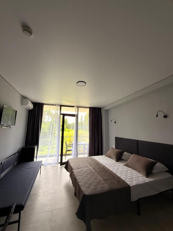a bedroom with a large bed and a large window at Sunny Gardens in Shekhvetili
