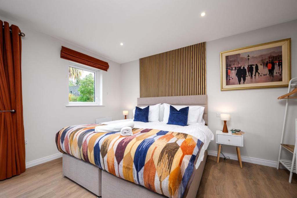 a bedroom with a large bed with a colorful blanket at Cherry Lodge by Escape Ordinary in Coleraine