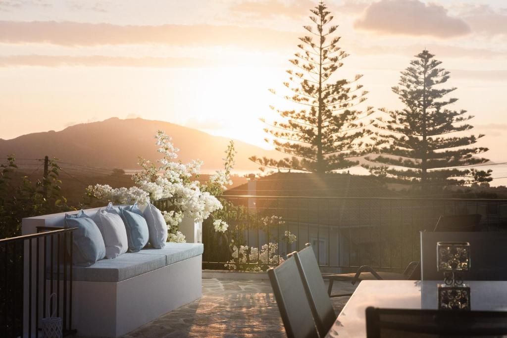 a patio with a couch and trees and the sunset at Dream View Loft in Lithakia