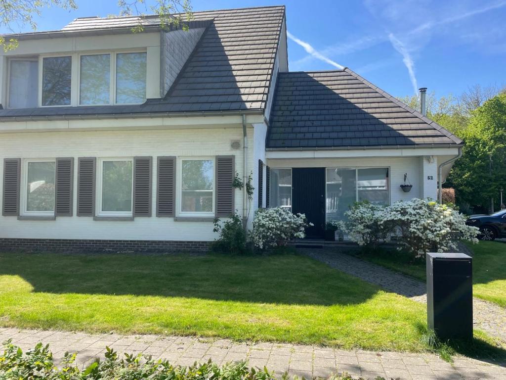 a white house with a black roof at TML Music Guesthouse in Aartselaar