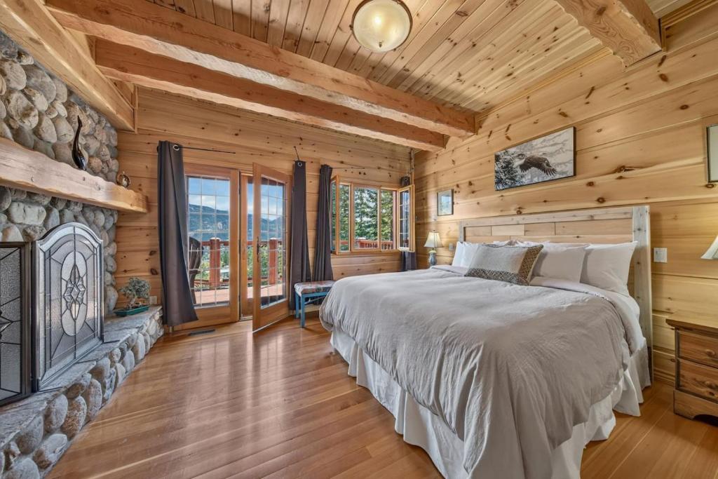 a bedroom with a bed and a fireplace at Mountain View Log Home in Invermere in Invermere