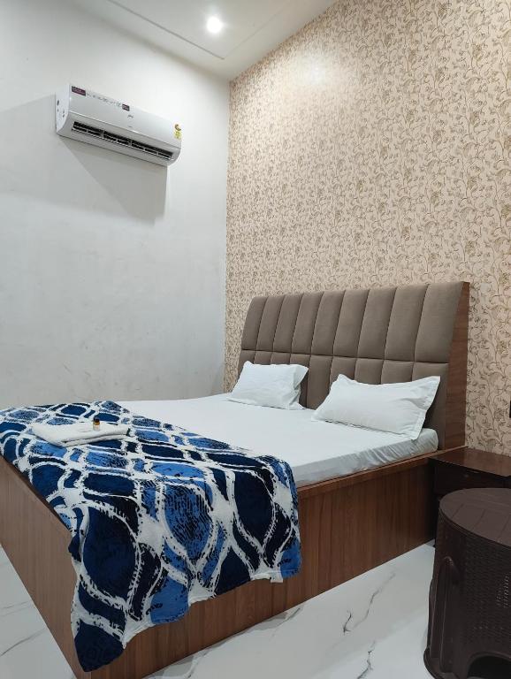 a bedroom with a bed and a air conditioner on the wall at Hotel Town Inn in Mathura