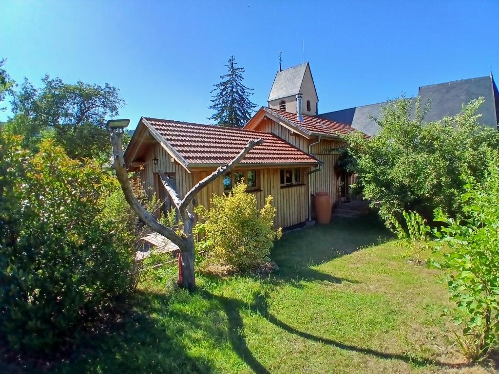 a house with a church with a yard at Le Rucher de St Pierre in Sainte-Marie-aux-Mines
