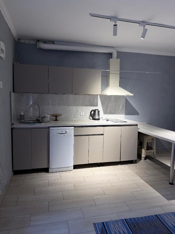 a kitchen with white cabinets and a table in it at Бухта in Nova Dofinivka