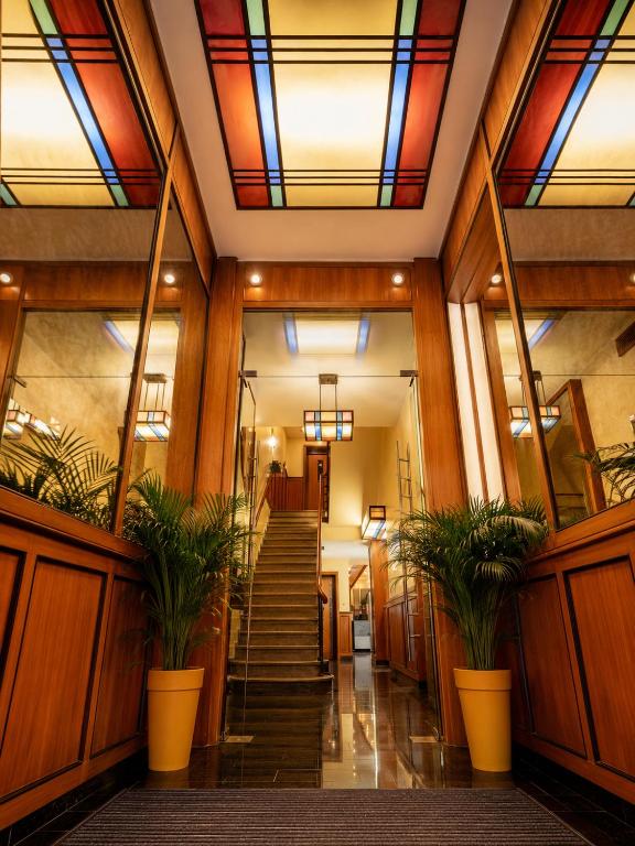 a hallway with stained glass ceilings and plants at HOTEL de la POSTE in Esch-sur-Alzette