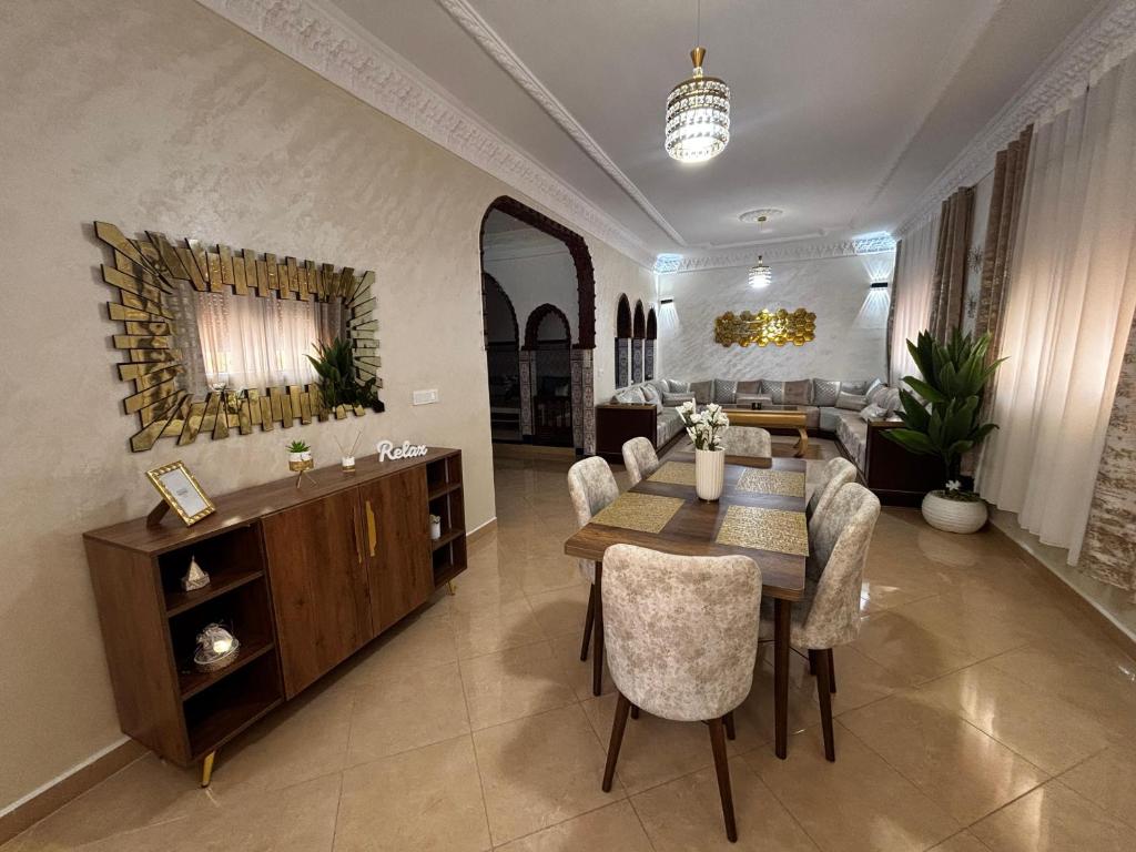 a living room with a table and chairs and a couch at Apartamento Fnideq, Familia, Bienestar y mercado in Riffiene