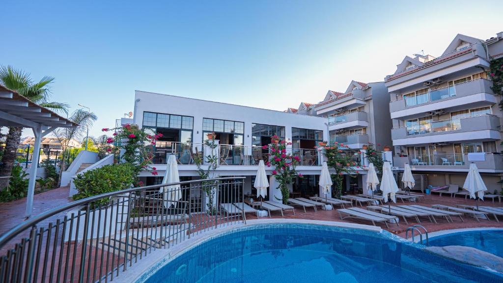 a hotel with a swimming pool in front of a building at Begonville Hotel in Marmaris