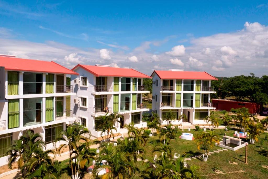 una fila de edificios de apartamentos con techos rojos en Inani Royal Resort, en Ināni